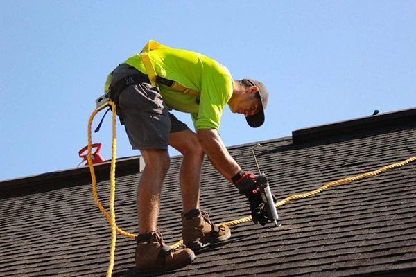 man-working-on-a-roof-with-a-power-drill