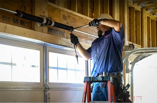 A Professional repairing a roll-up gate