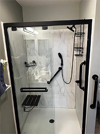 Grab bar mounted beside a walk-in shower with a fold-down seat