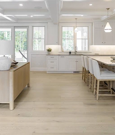 Wide plank flooring with a wood cabinet and table.